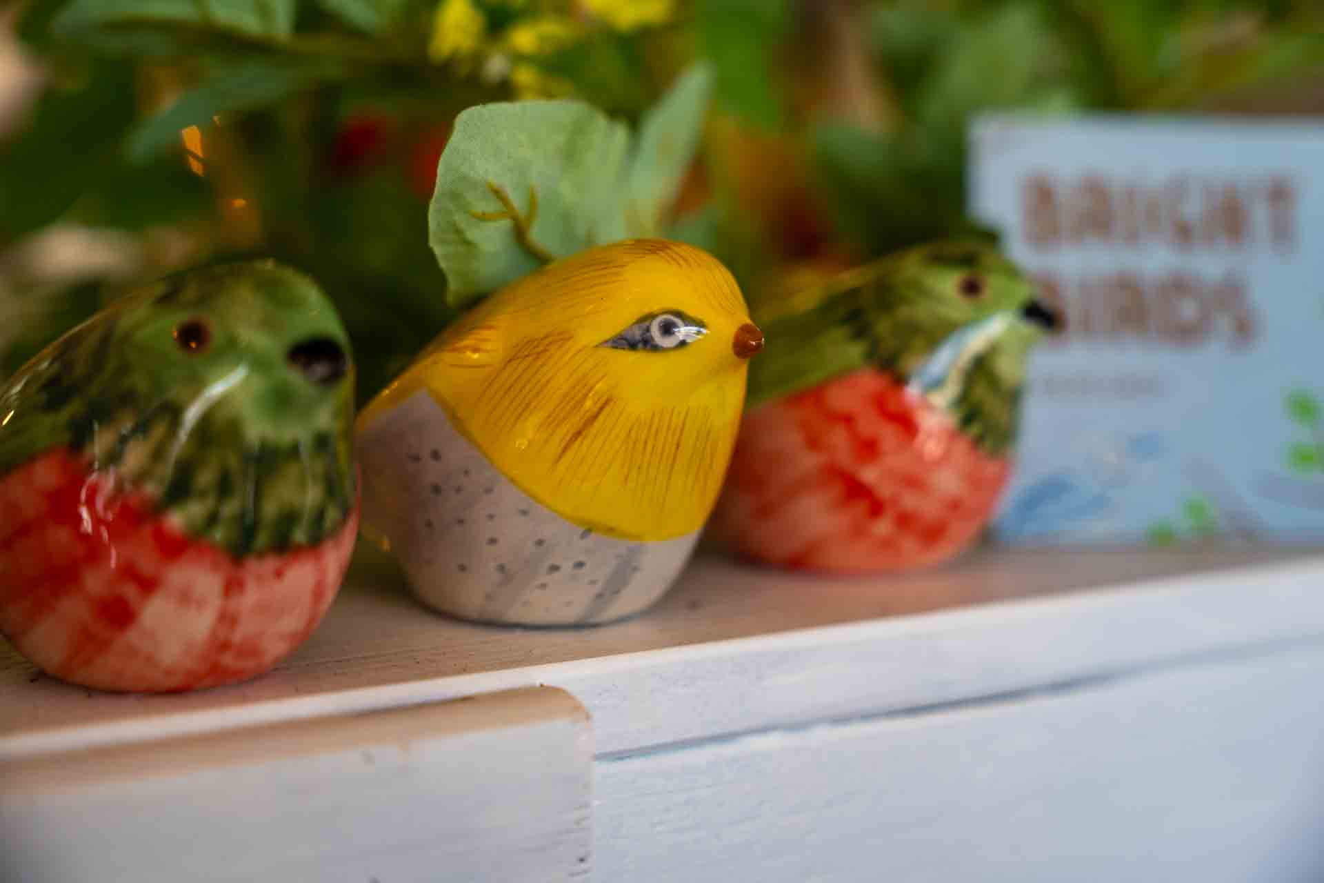 Colorful ceramic bird figurines on display at Barn and Charm, a local rustic decor shop