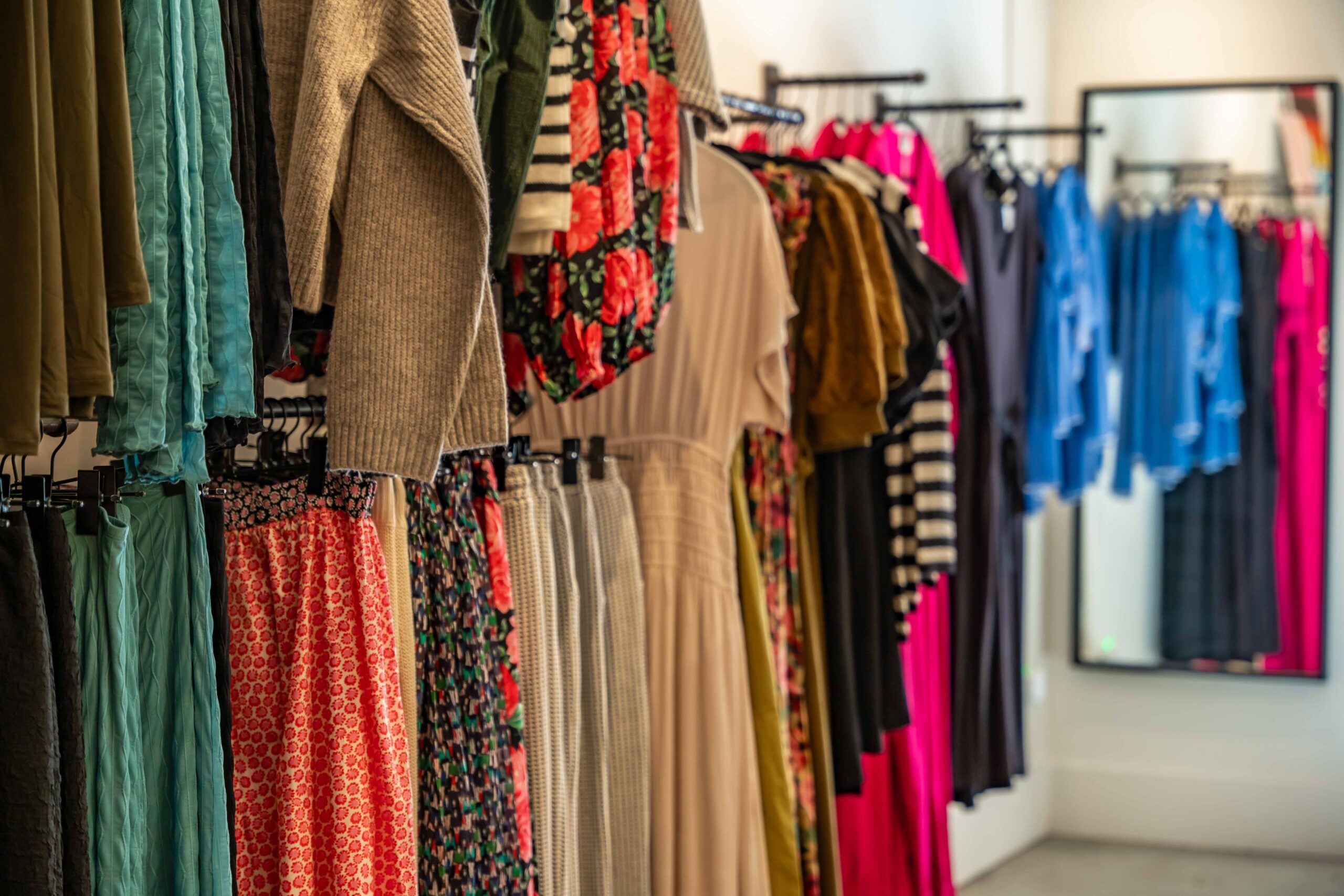 A Clothing rack displays floral and solid dress patterns available at Form and Content, Women's, clothing store, Newhall California