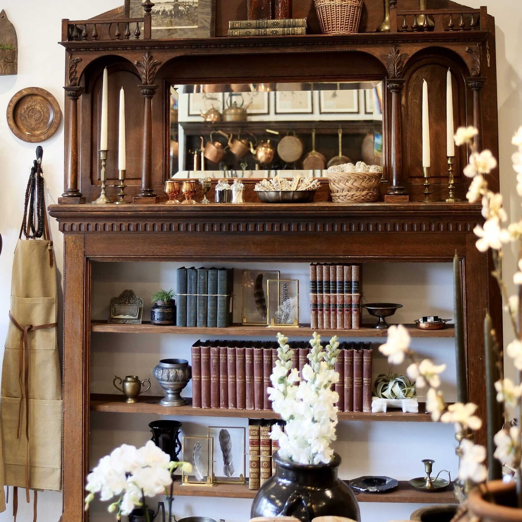 Antique wooden bookshelf with a built-in mirror and display shelf.