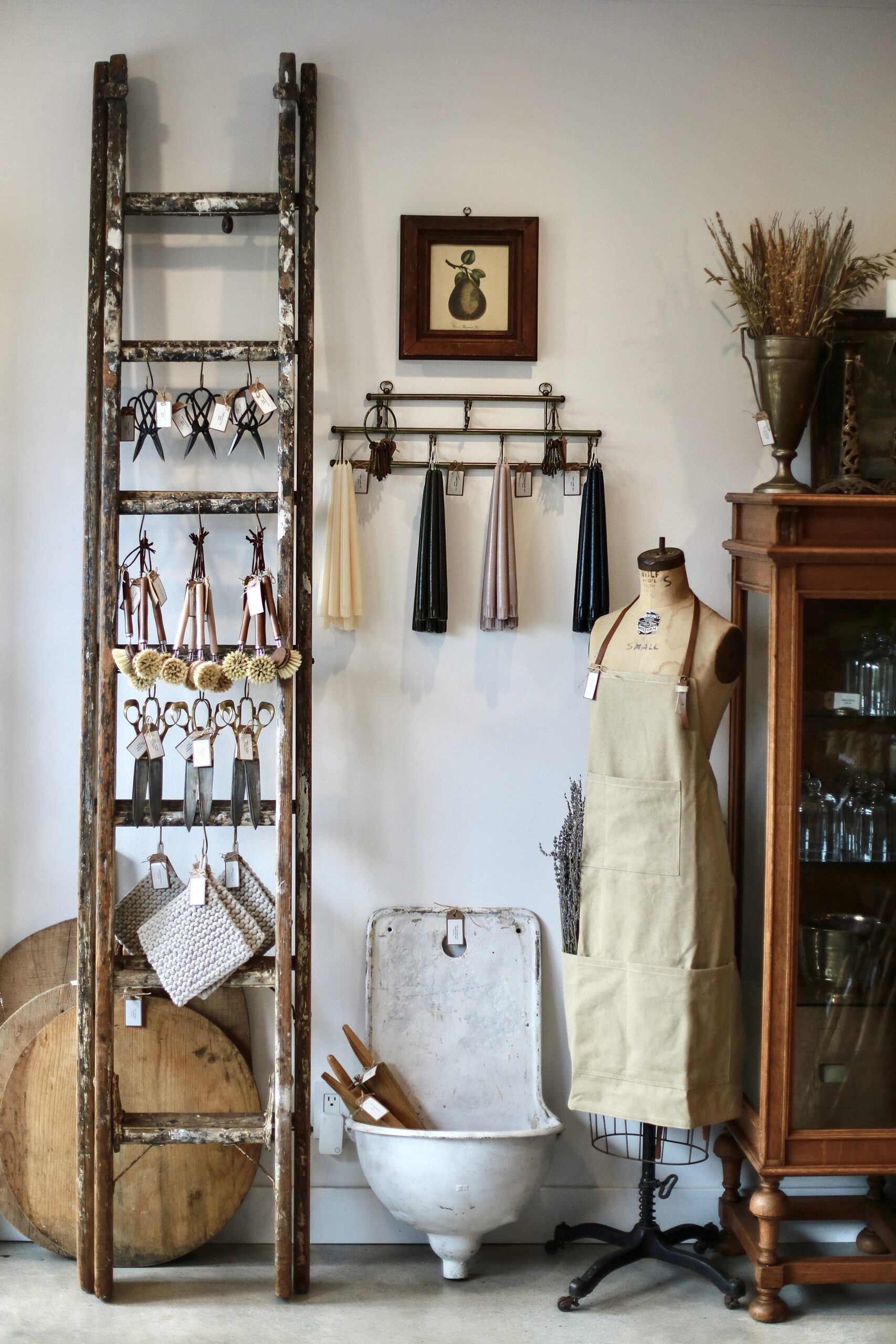 Display at Heirloom Vintage in Newhall, California, featuring antique ladder, hanging scissors, aprons, and vintage decor