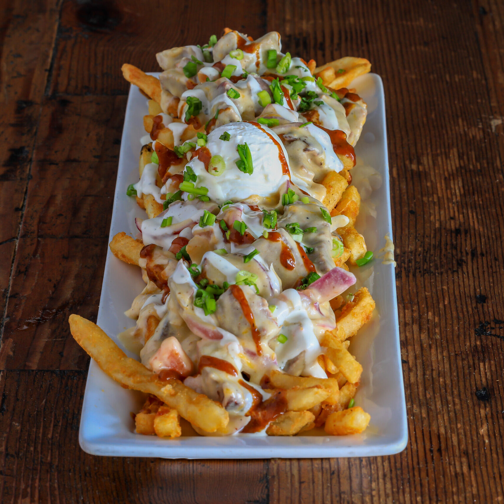 smokehouse on mains pitmaster fries. fries covered in cheese sour cream green onions and dressing