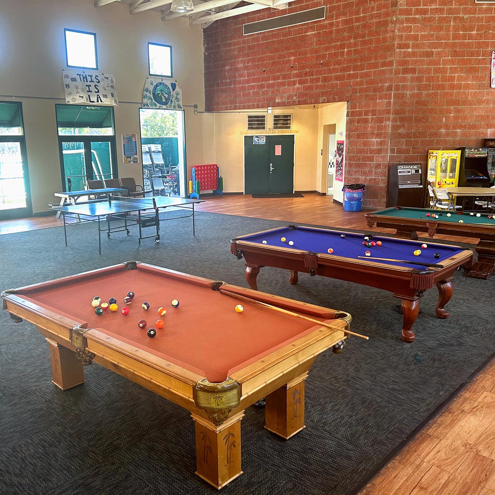 Newhall SCV boys and girls Club recreation room, featuring pool tables, table tennis, and arcade machines