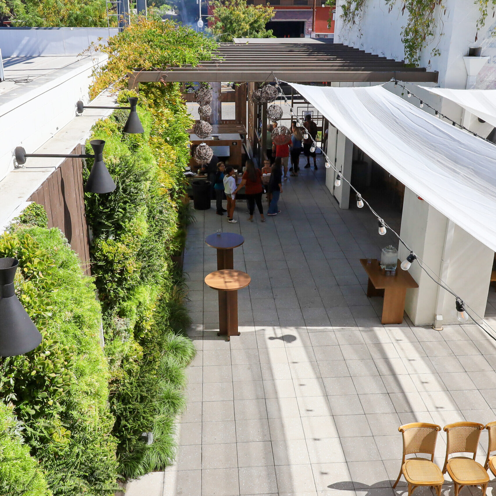 Outdoor event space at Hart & Main in Newhall, California, featuring greenery, modern decor, and shaded seating.