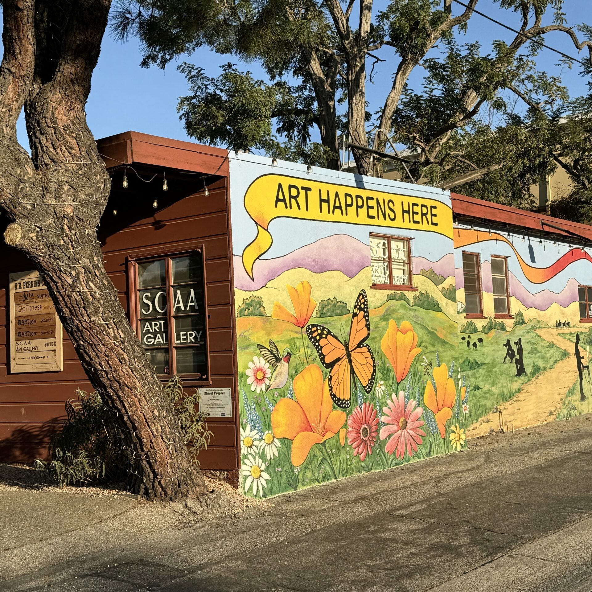 A beautiful Mural featuring a monarch butterfly and poppy flowers on the Storefront of the Santa Clarita Artists Association (SCAA) building