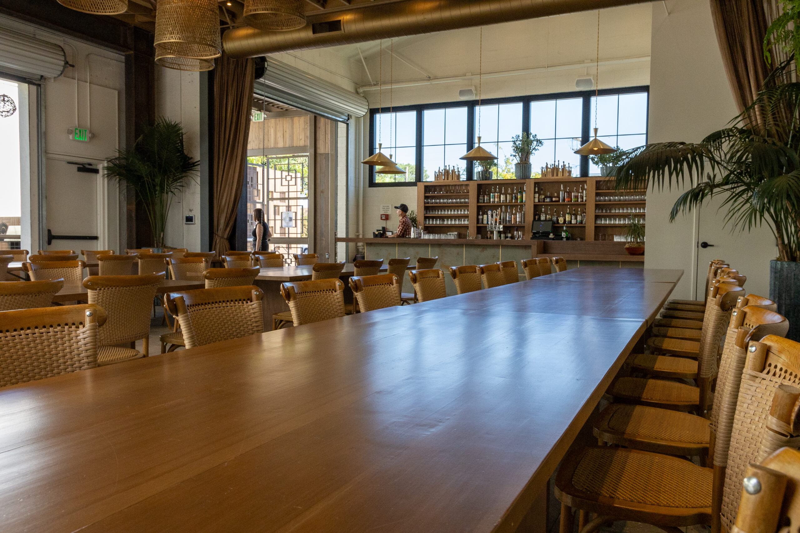 Dining area at Hart & Main in Newhall, California, featuring Long oak tables and a fully stocked bar